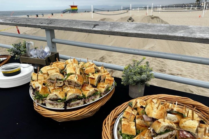 a plate of food on a picnic table by the beach on a bike food tour