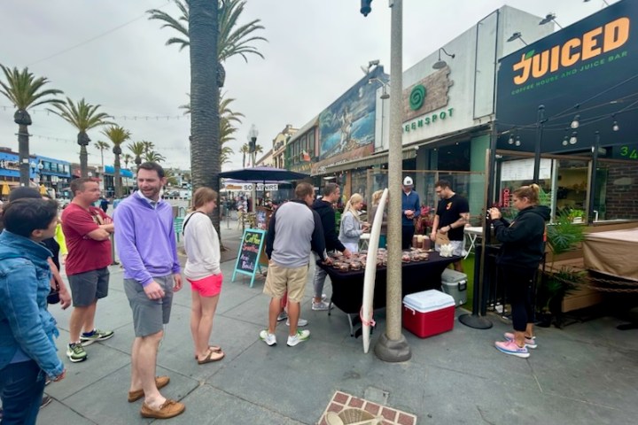 a group of people standing in hermosa beach on an la food tour