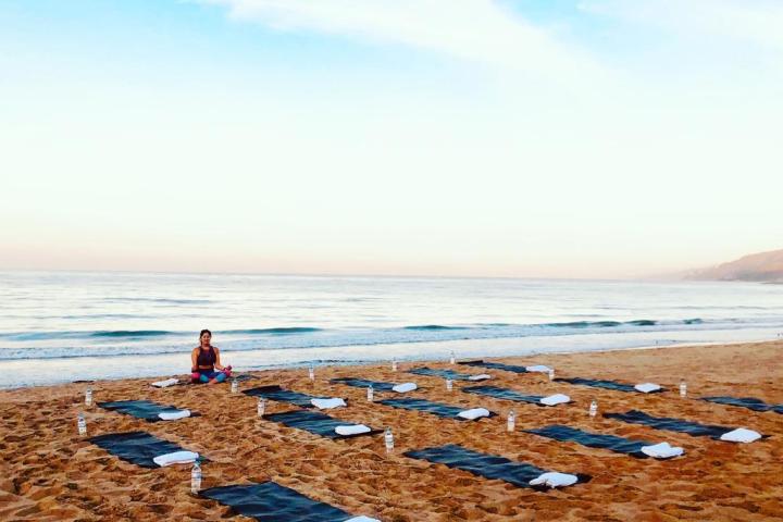 a group of people doing yoga on a beach
