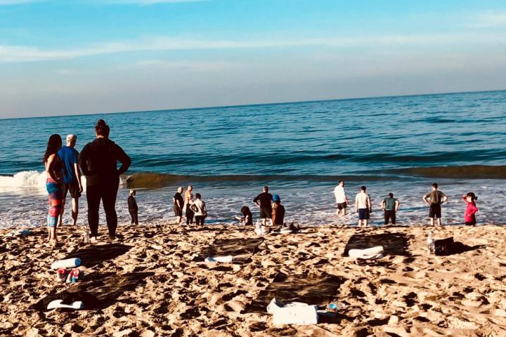 a group of people doing yoga on the beach