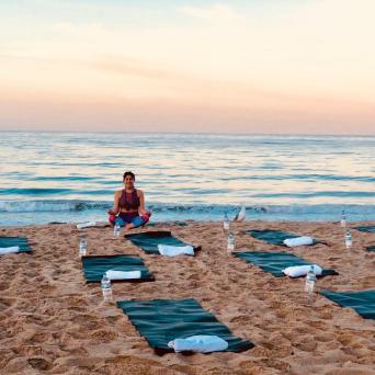 a group of people goin yoga on a beach on a los angeles tour
