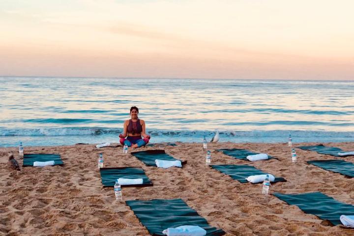 a group of people goin yoga on a beach on a los angeles tour