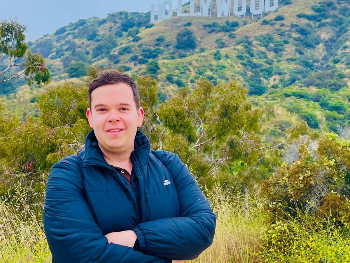 man standing in front of the hollywood sign