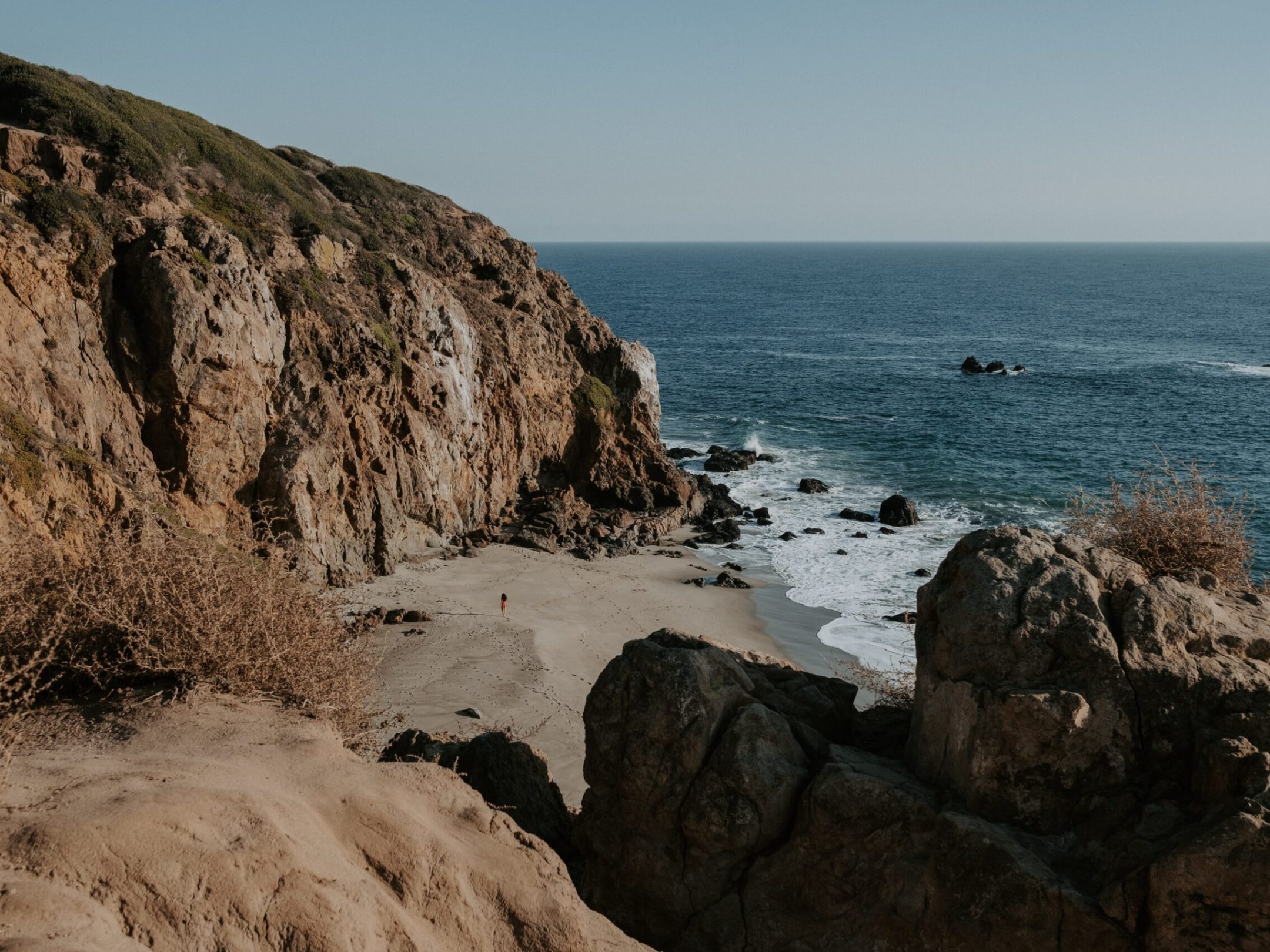 a rocky island in the middle of a body of water