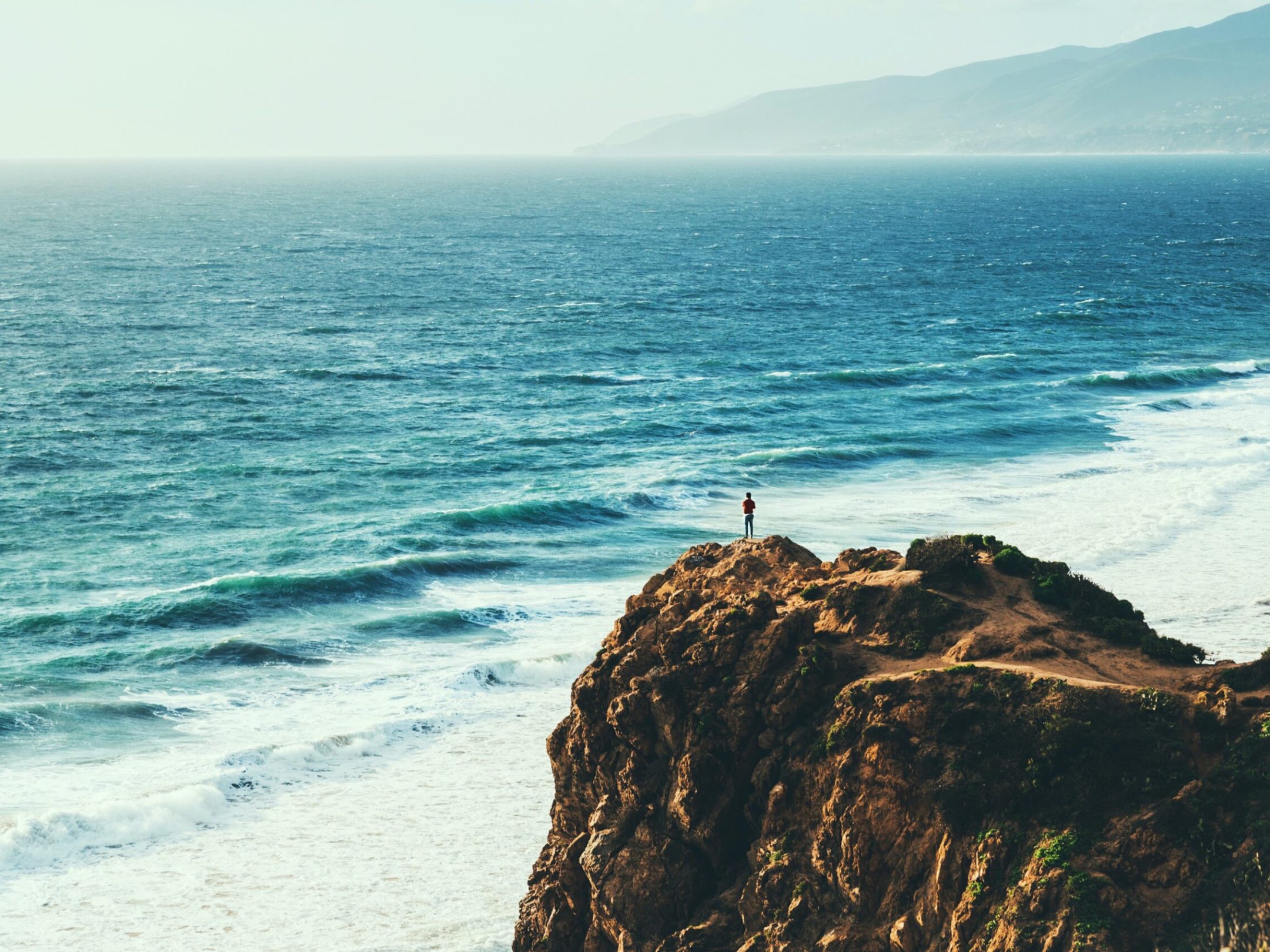a body of water with a mountain in the ocean