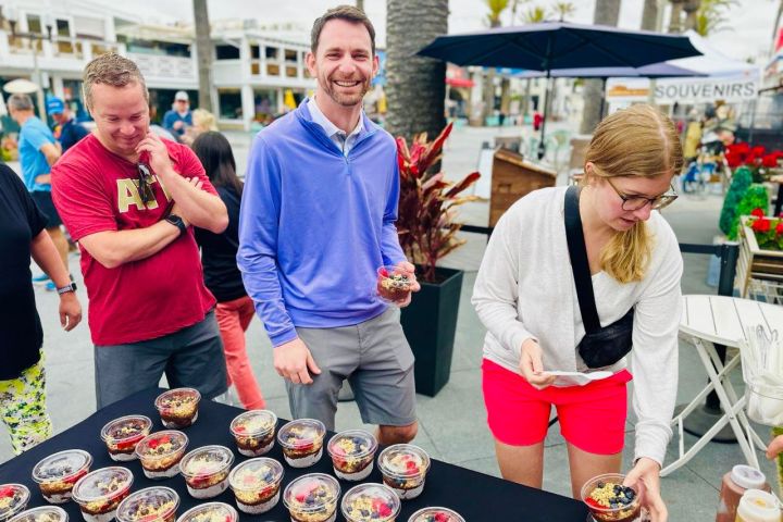 a group of people standing around a table on a bikes and bites food tour