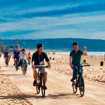 a man riding a bicycle on a beach