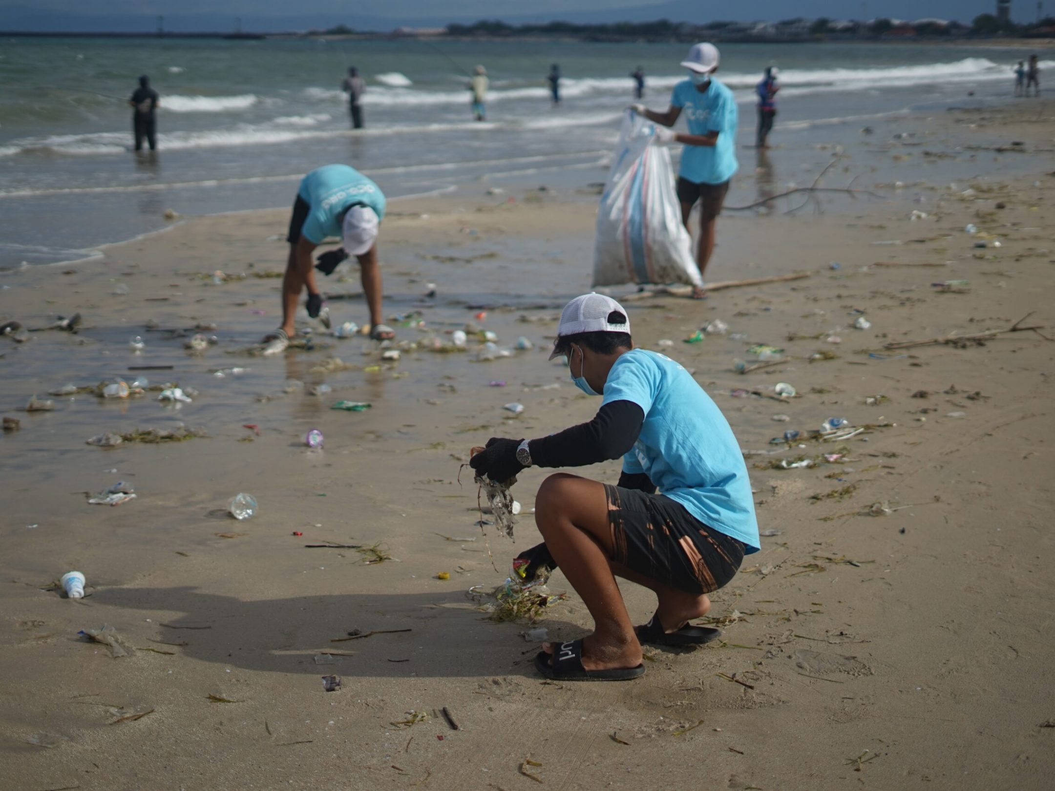 a group of people on a beach doing a beach clean up