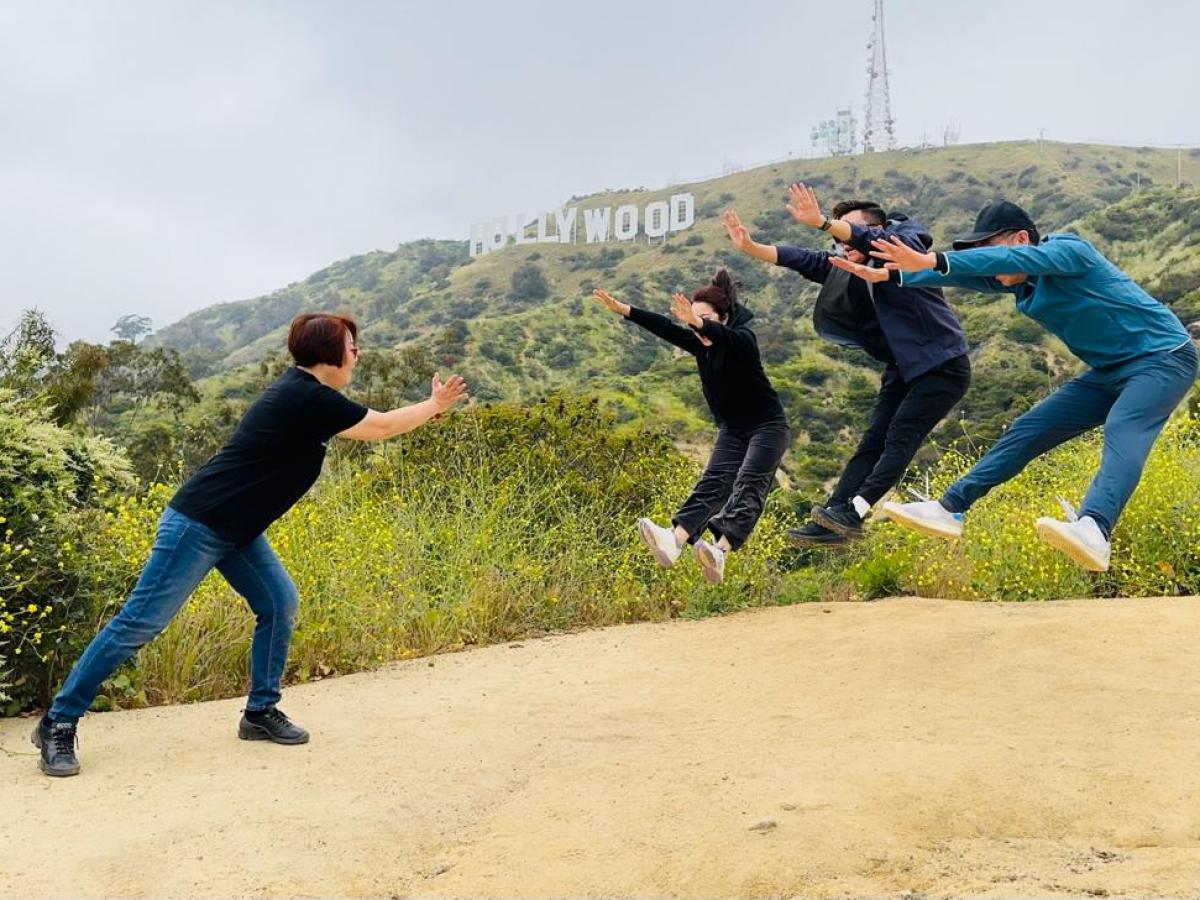 Tourists doing a cool post with the Hollywood Sign