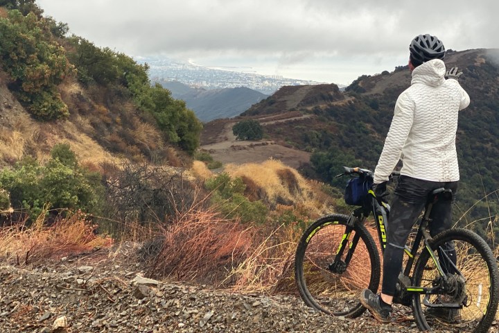 a man riding a bike down a dirt road