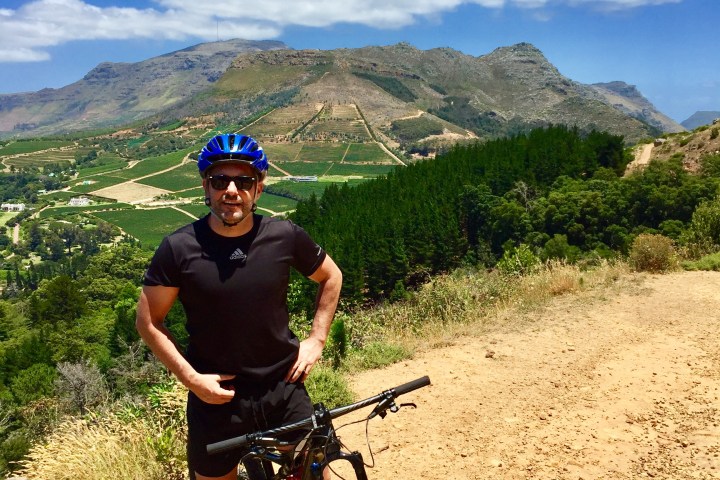 a man riding a bike down a dirt road