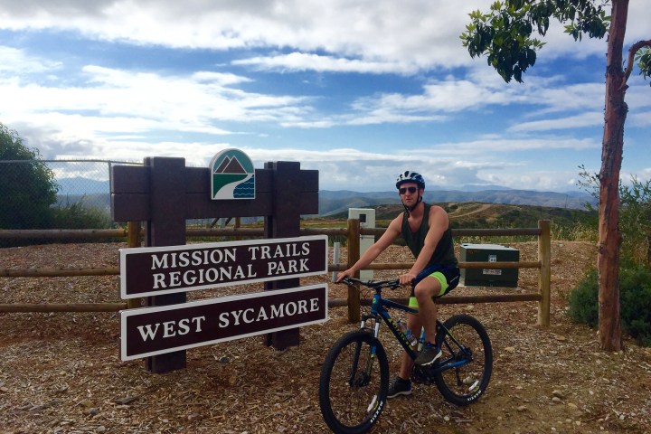 a man riding a bike down a dirt road