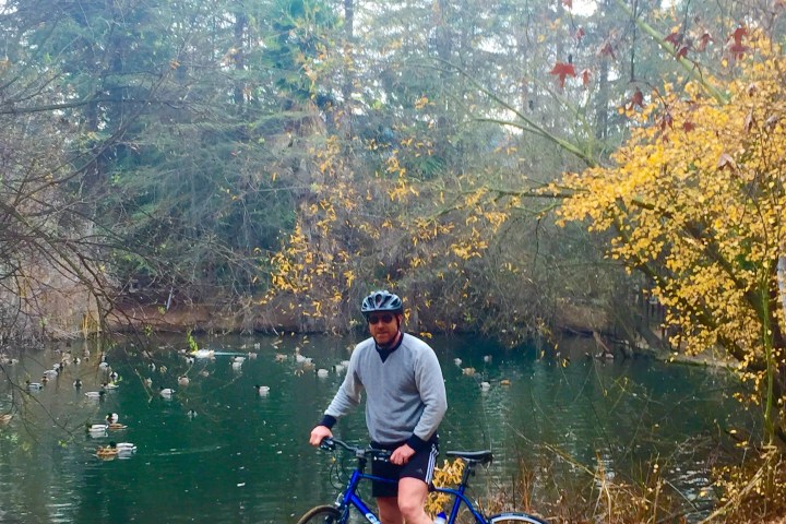 a man riding a bicycle next to a lake