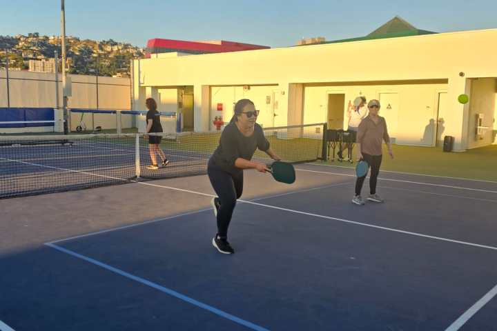a group of people on a court with a racket