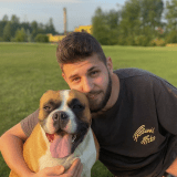a man holding a dog posing for the camera
