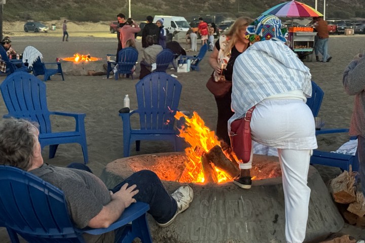 a group of people sitting around a fire