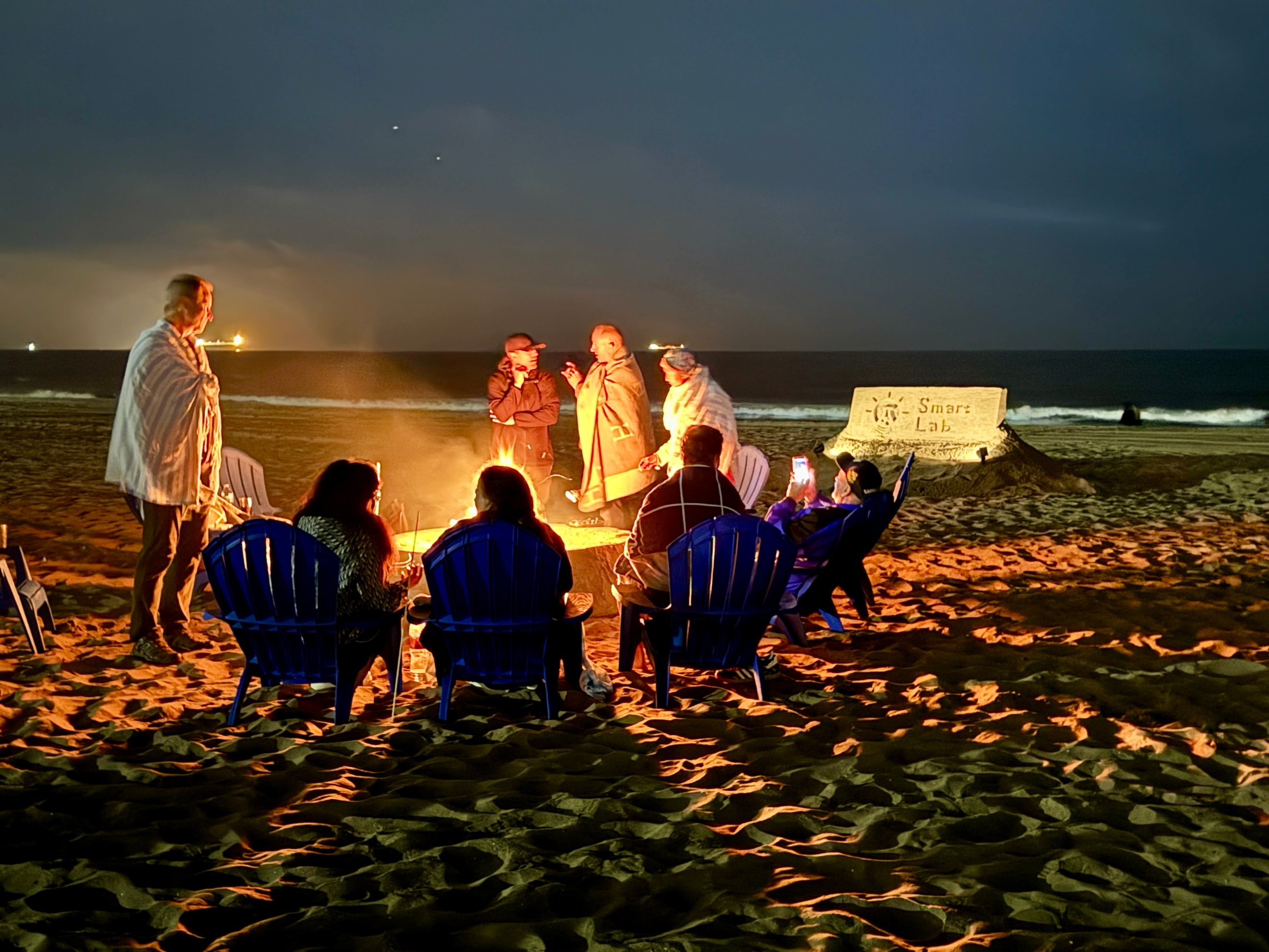 a group of people sitting at a beach