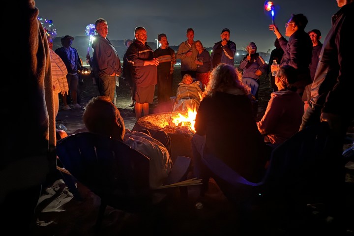 a group of people standing around a fire
