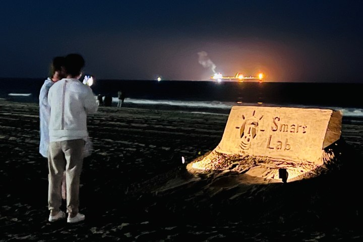 a man and a woman standing in front of a sign